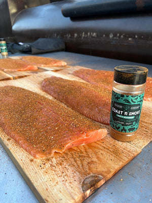 Salmon on cedar planks ready to be smoked, seasoned with a spice blend