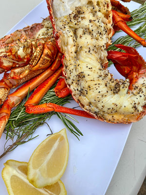delicious lobster on a platter with lemon wedges seasoned with salt, pepper and garlic