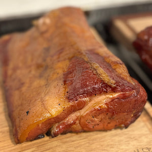 Smoked meat on a wooden cutting board with a blurred background