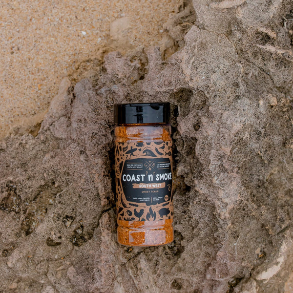 A shaker of the SouthWest spice blend on a rock on the sand