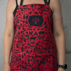 person wearing red apron with black icons and logo