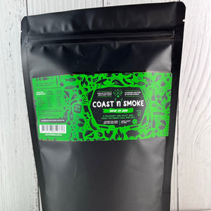 A black pouch container with a vibrant green label decorated with surfing and food icons